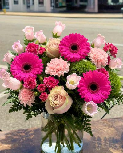 <p>Pink roses, lilies, spray roses, carnations and greens designed in a glass cylinder.</p>