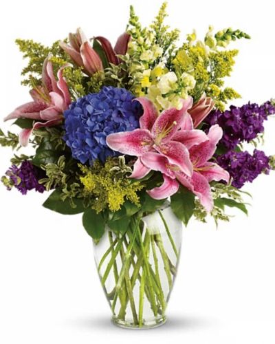 <p>Oriental lilies, indigo hydrangeas, fragrant stock, fresh Florida snap dragons and more in a clear glass vase</p>