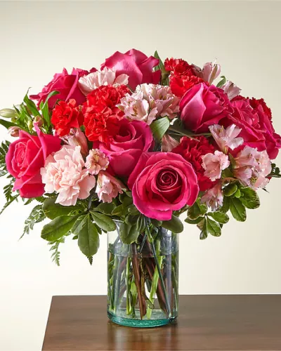 Blushing shades of pink blooms are nestled in lush greens to charm anyone's day. This bouquet is abundant with a classic assortment of pretty florals – roses, alstroemeria and carnations to name a few.