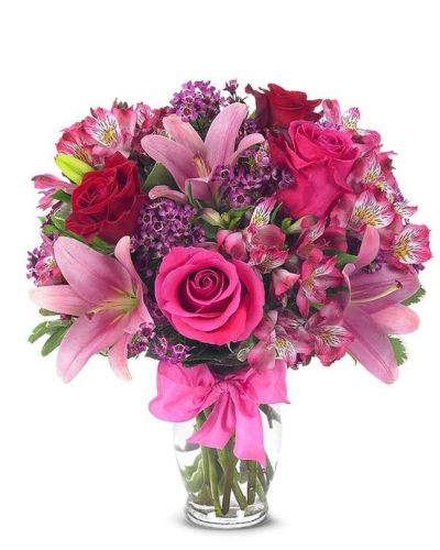 This sweetly flirtatious combination of Asiatic lilies, waxflower, alstroemeria and roses makes a thoughtful gift they'll not soon forget. A pretty pink ribbon and clear fluted glass vase add to the romantic look.