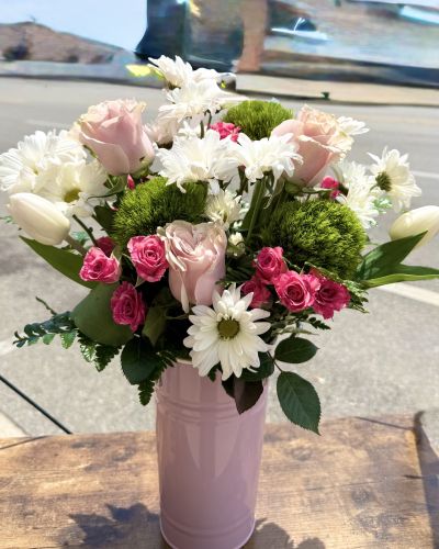 Shades of pinks and whites in this keepsake container. Featuring roses, spray roses daisy's tulips and more!