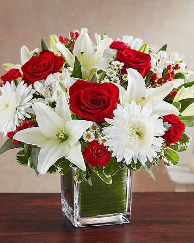 The color most related the heart, let red serve as a reminder that you're thinking of them. Our arrangement of timeless red roses, carnations, and white lilies, expertly gathered together in a clear vase, it is an exquisite gesture of sentiment and caring.