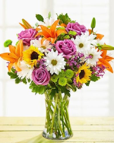 Make their day twice as nice…for the same price! Our vibrant bouquet of roses, lilies, sunflowers, button poms and more is artfully arranged so that you can express yourself perfectly for any reason, or no reason at all!